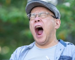 欠伸をする中年男性