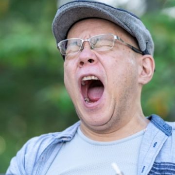 欠伸をする中年男性