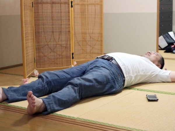 寝転がる中年男性のイメージ画像
