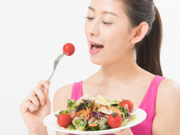 サラダを食べる女性のイメージ画像