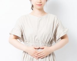 お腹に手を当てている女性のイメージ画像