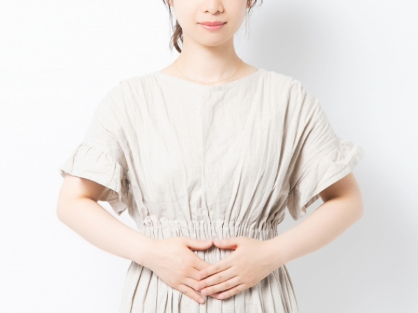お腹に手を当てている女性のイメージ画像