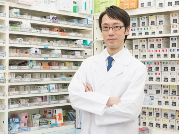 薬棚の前の男性薬剤師のイメージ画像