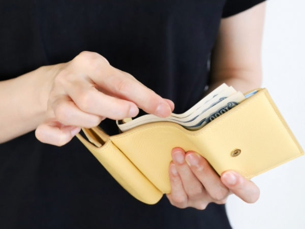 財布からお札を出す人のイメージ画像