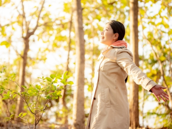 自然の中で深呼吸をしている女性のイメージ画像