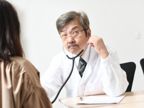 診察する男性医師と女性患者