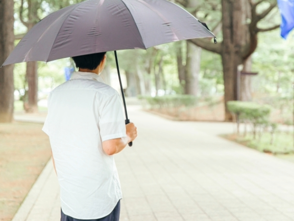 日傘をさす男性のイメージ画像
