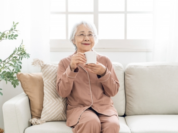 ホットドリンクを飲むシニア女性のイメージ画像