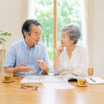 検査結果を見ながら健康について話し合っているシニア夫婦のイメージ画像