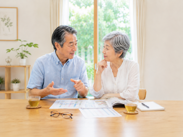 検査結果を見ながら健康について話し合っているシニア夫婦のイメージ画像