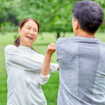 外でストレッチを行うシニア夫婦