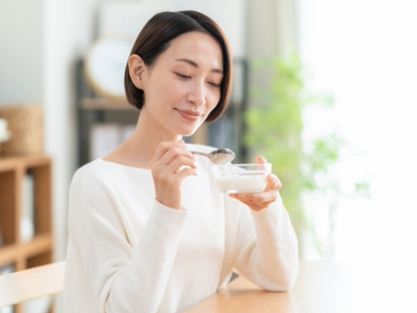 ヨーグルトを食べる女性のイメージ画像