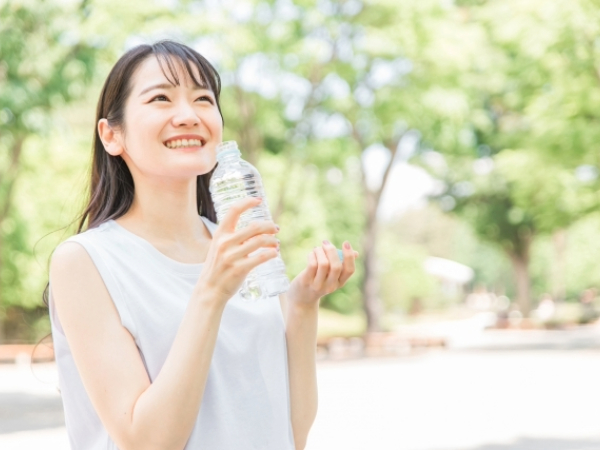 水を飲む女性、ノースリーブ、夏、ロングヘア、ペットボトルを持つ姿のイメージ画像