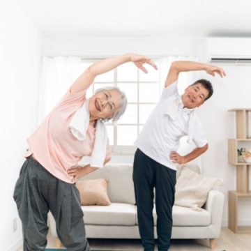 室内でラジオ体操をする夫婦のイメージ画像