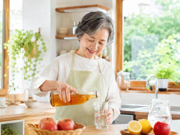 リンゴ酢を薄めているシニア女性のイメージ画像