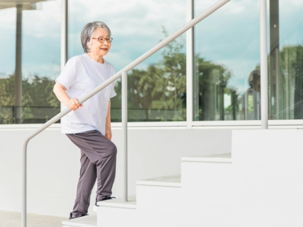 階段で運動するシニア女性のイメージ画像