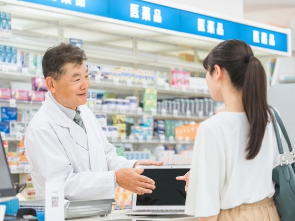 薬剤師さんから薬の説明を受けている女性のイメージ画像