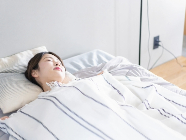 ベッドで熟睡する女性のイメージ画像