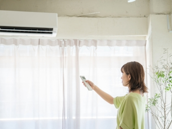エアコンを操作している女性のイメージ画像