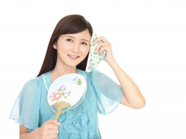 汗をぬぐう女性のイメージ画像