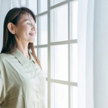 深呼吸をするシニア女性のイメージ画像
