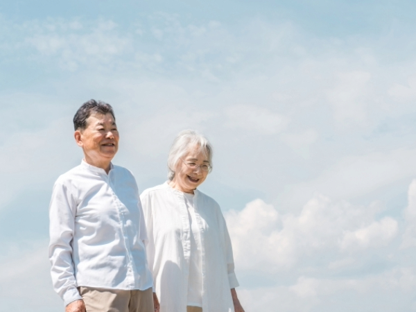 会話をしながら散歩を楽しむシニア夫婦のイメージ画像