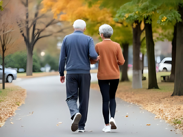 紅葉の中ウォーキングをするシニア夫婦