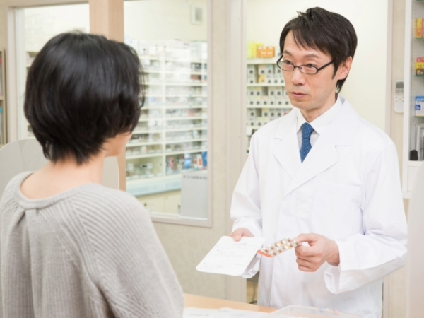 薬剤師に薬の説明を受ける女性のイメージ画像