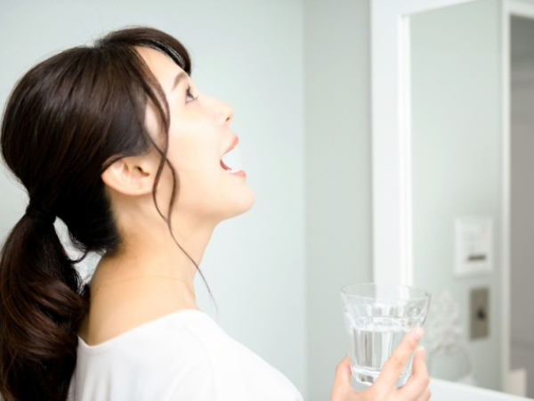 うがいをする女性のイメージ画像