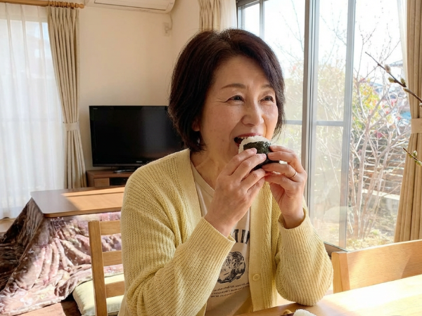 おにぎりを食べる女性のイメージ画像